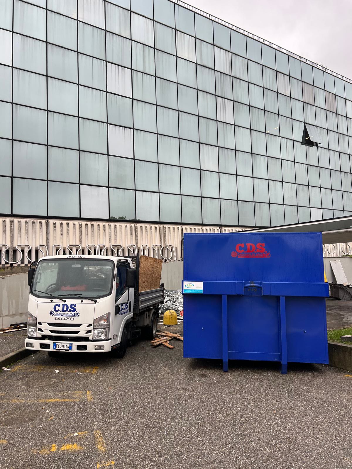 Autocarro e cassone C.D.S. davanti a un edificio direzionale